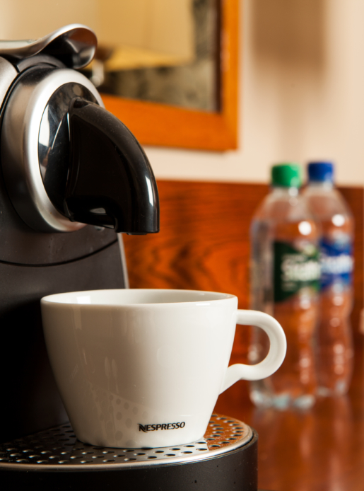 Nespresso coffee machine and bottled water in bedroom at Mercure Hotel