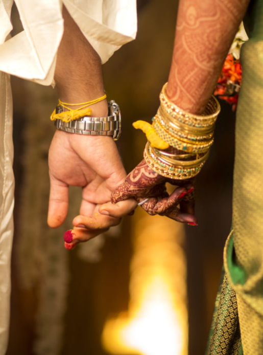 Close up of groom holding brides hand in south Indian wedding ceremony