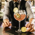 Barman serves a cocktail in large glass