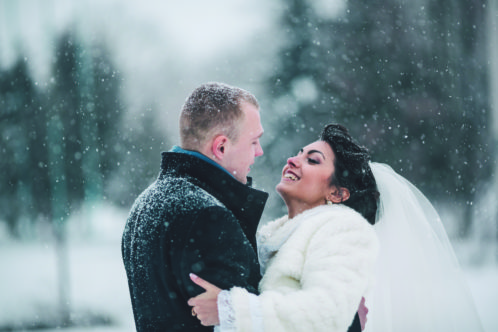 bride and groom in a winter frost with a snowflow