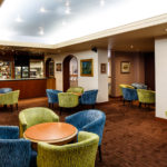 The bar and lounge area at Mercure Norwich Hotel, blue and green armchairs