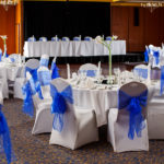 The City Suite at Mercure Norwich Hotel, set up for a wedding breakfast, white linen with blue sashes