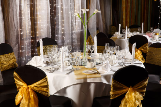 The City Suite at Mercure Norwich Hotel, set up for a wedding breakfast, black linen with yellow sashes