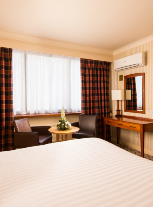 Classic double bedroom at Mercure Norwich Hotel, double bed, side table and desk with TV