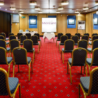 The Presidential Suite at Mercure Norwich Hotel set up for a meeting, projector, presentation board