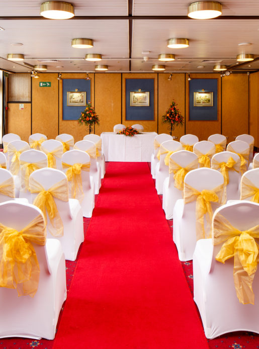 The Presidential Suite at Mercure Norwich Hotel set up for a wedding ceremony, red carpet aisle, white and yellow theme