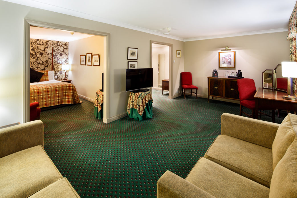 Superior bedroom at Mercure Norwich Hotel, bed area, seating area with sofas and TV, dressing area